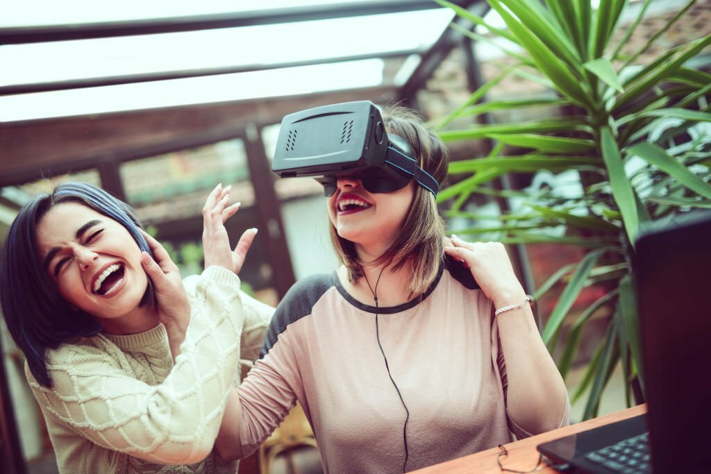 Two Girls Having Fun with Virtual Reality Simulator 